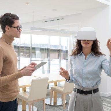 Young female developer making a presentation to colleague with tablet